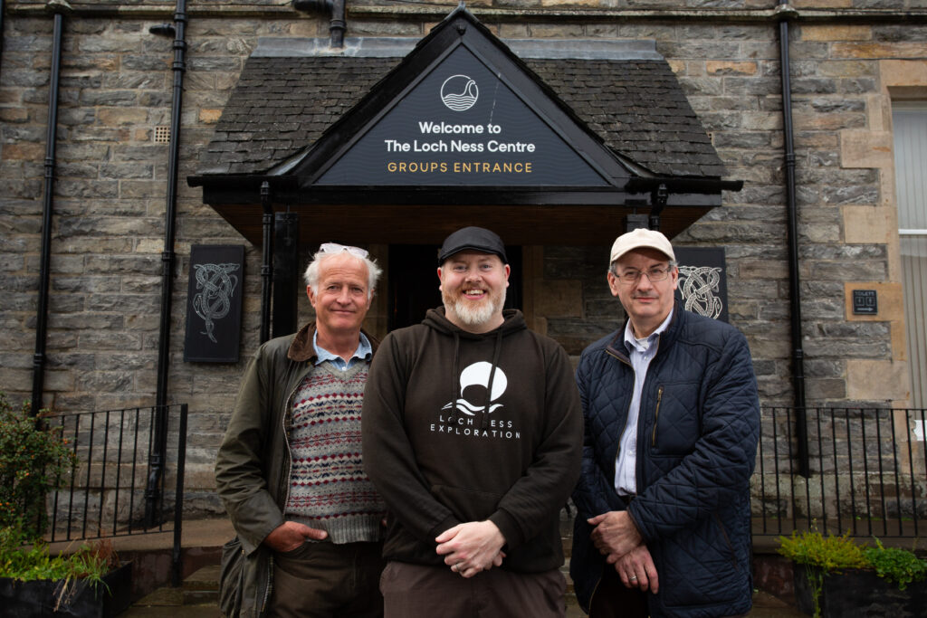 Legendary Nessie hunter Steve Feltham, Loch Ness Explorations' Alan McKenna, and author, Roland Watson stood outside the Loch Ness Centre in the Scottish Highlands