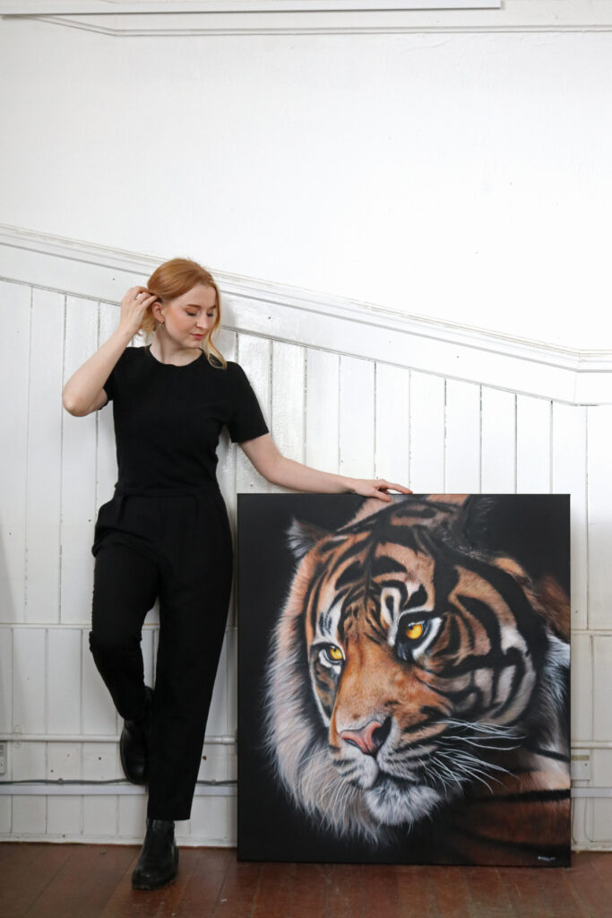 Wildlife artist Kirsten Mirrey posing with painting