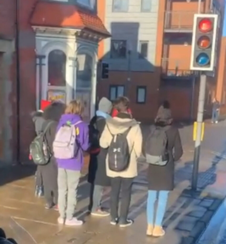 The students waiting at the red light