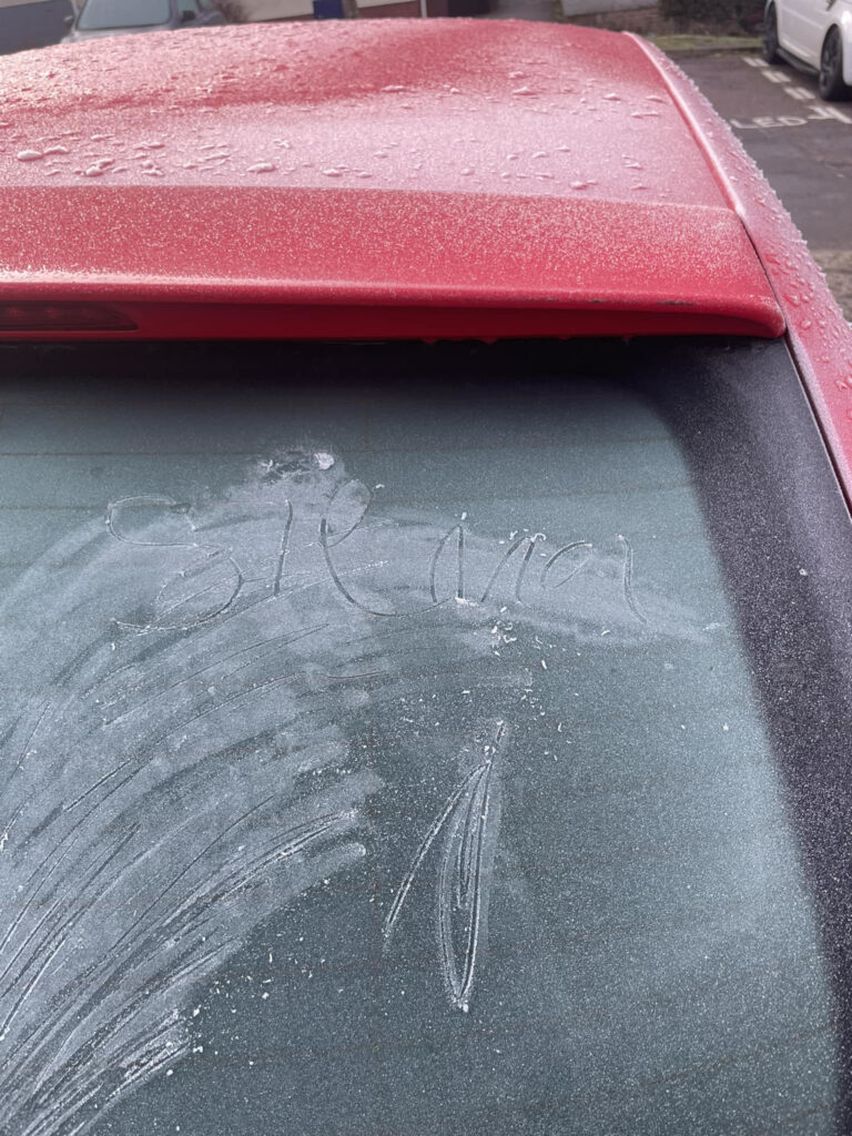A frosted windshield with the name Sienna