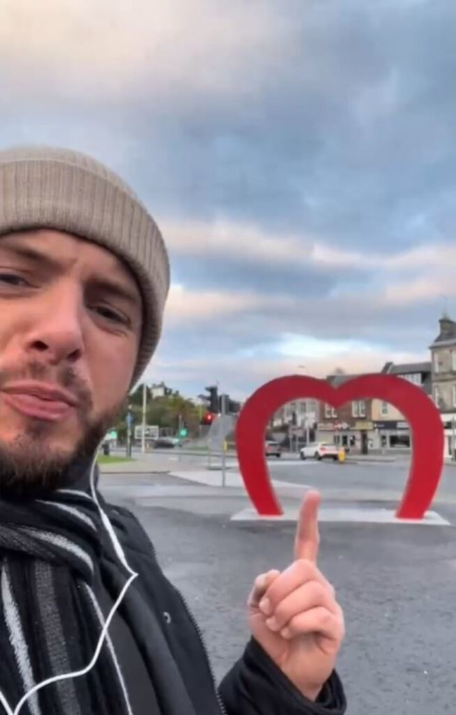 Lewis pointing to the heart statue in Kirkcaldy.