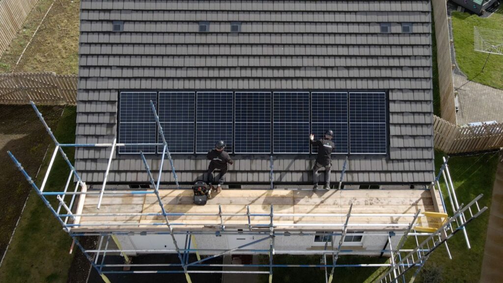 Above view of solar panels being installed on a roof.