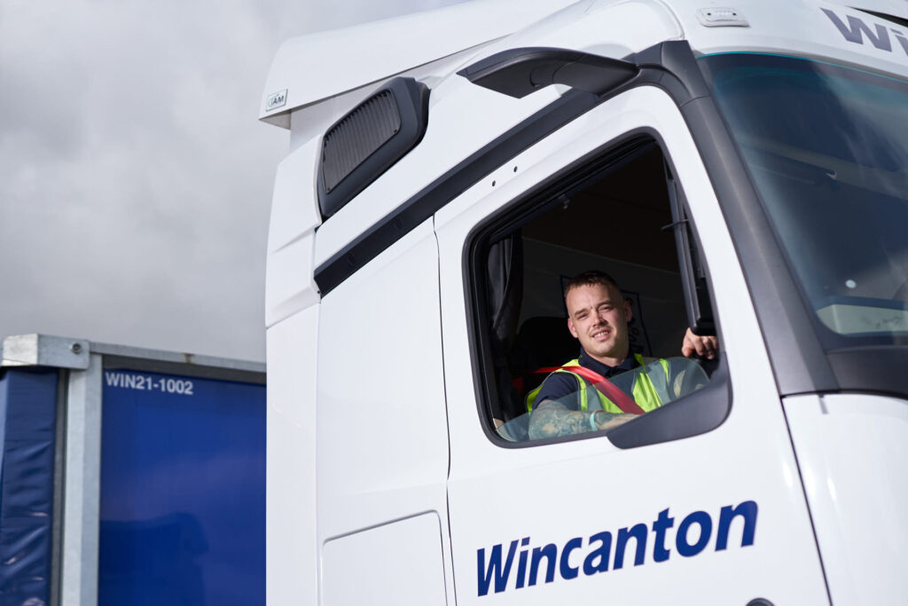 Driver smiling from large Wincanton lorry.