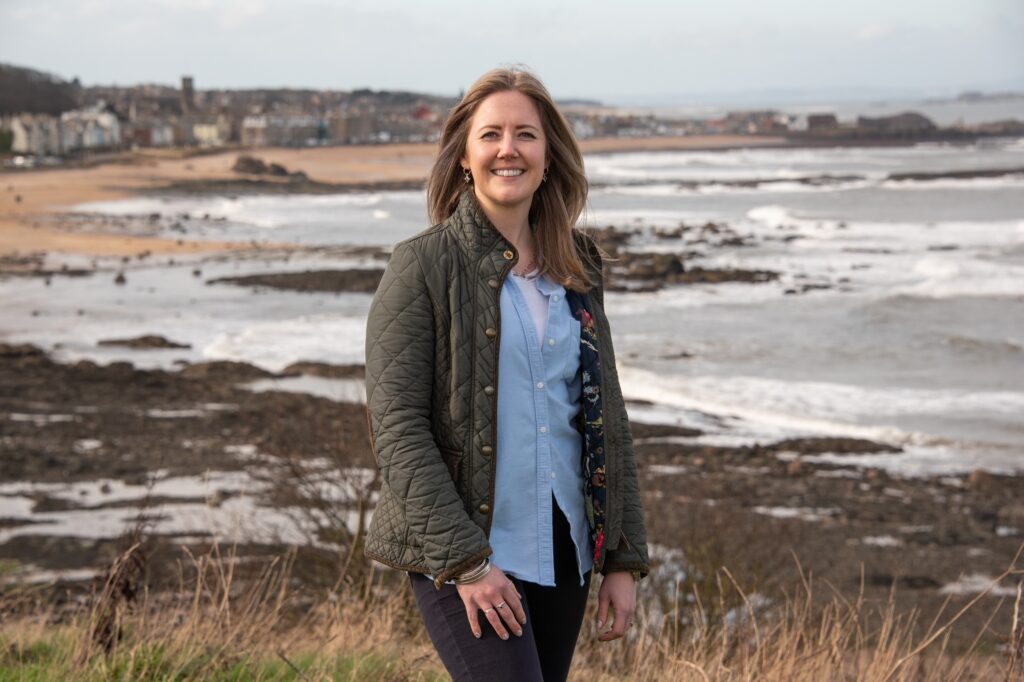 Charlotte Murray stood on the coast with North Berwick in the background (image supplied with release by Simpson and Marwick)