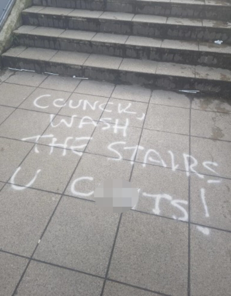 Steps in Brighton with graffiti on the pavement asking for the graffiti to be cleaned up