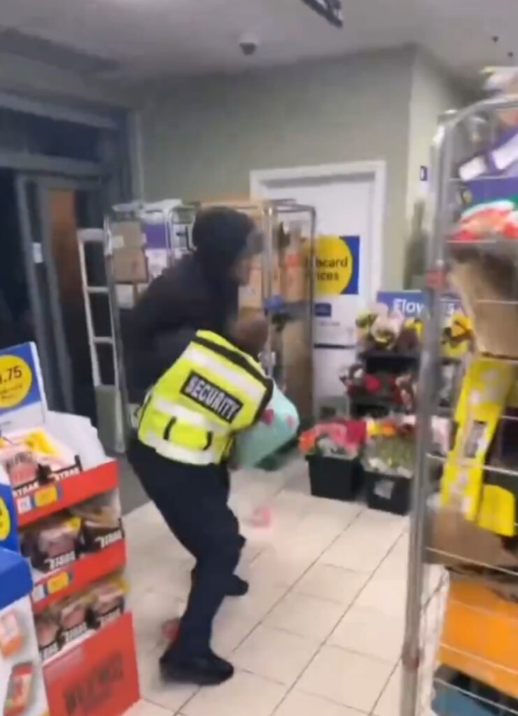 The shoplifter put the security guard in a headlock.