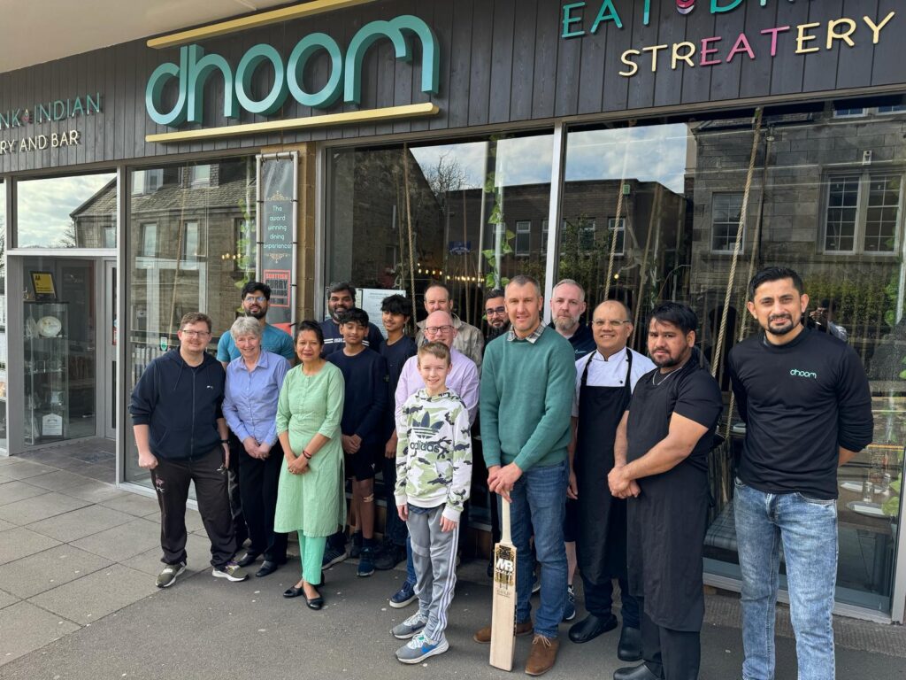 Dunfermline & Carnegie Cricket Club and Dhoom Indian Streatery & Bar smile for a group photo outside of Dhoom restaurant.