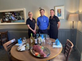 Red House Hotel staff and Sean Davidson stand next to a table. Image supplied with release by Advantage PR